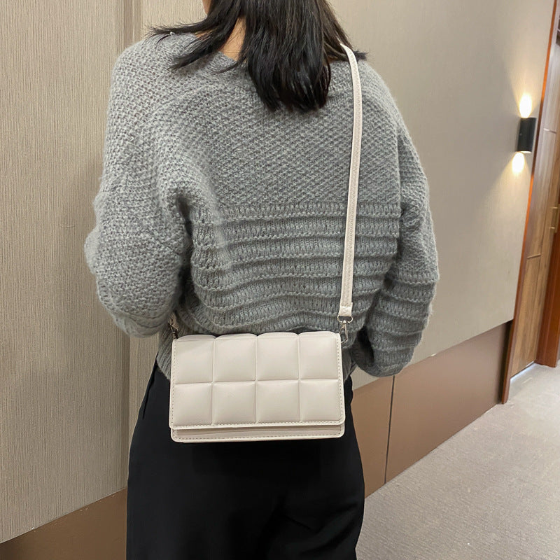 A small square bag with one shoulder and cross body